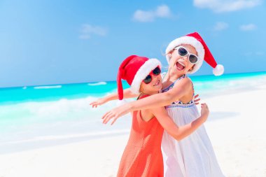 Çok güzel küçük çocuklar Santa şapka Noel beach tatil sırasında. Sahilde yeni yıl