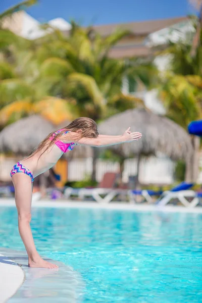 Pequena garota adorável ativa na piscina exterior pronta para nadar — Fotografia de Stock