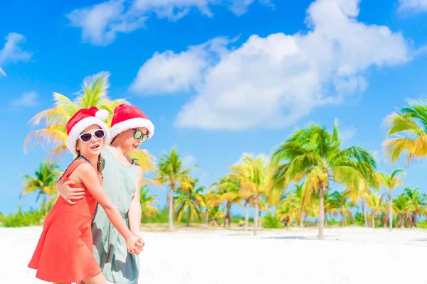 Glückliche Kinder haben während der Weihnachtsferien am Strand viel Spaß mit dem Weihnachtsmann. Neues Jahr am Strand — Stockfoto
