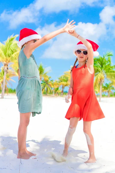 Schattig weinig kinderen in KERSTMUTS tijdens kerstvakantie strand. Nieuwjaar op het strand — Stockfoto