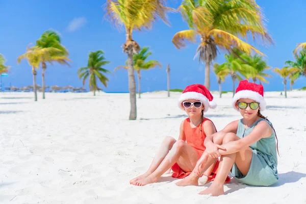 Entzückende kleine Kinder mit Weihnachtsmütze während der Weihnachtsferien am Strand. Neues Jahr am Strand — Stockfoto