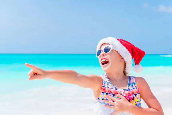 Adorable petite fille dans le chapeau de Père Noël pendant les vacances de plage de Noël — Photo