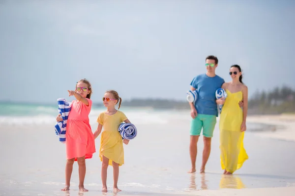 Familia joven en la playa. Niños pequeños con toallas —  Fotos de Stock