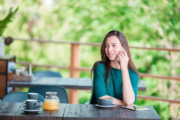Женщина наслаждается вкусным кофе, завтракающим в кафе на открытом воздухе. Счастливая городская женщина пьет кофе — стоковое фото