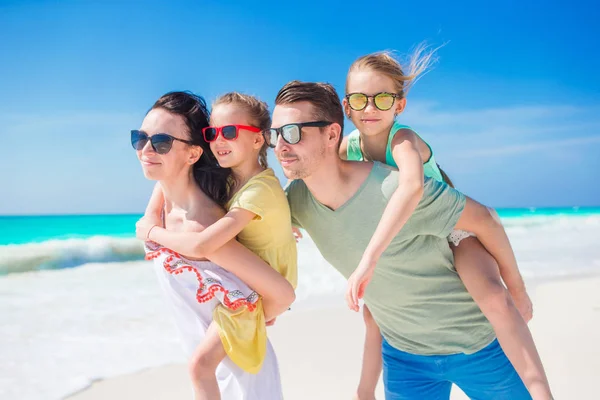 Feliz hermosa familia de cuatro en la playa de vacaciones —  Fotos de Stock