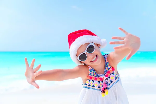 Gelukkig klein meisje in KERSTMUTS op strand kerstvakantie — Stockfoto