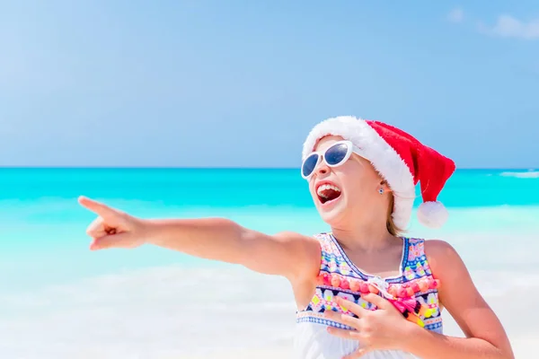 Szczęśliwy, śmieszne dziewczynki w Santa hat w Boże Narodzenie wakacje na plaży mieć dużo zabawy — Zdjęcie stockowe