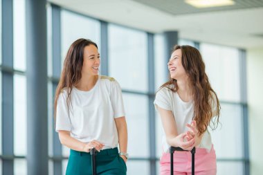 Uluslararası havaalanında bavul olan genç kadın. Havayolu Yolcu uçuş uçak için bekleyen bir Havaalanı Lounge