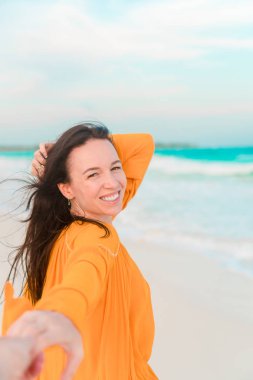 Genç güzel kadın beyaz tropikal kumsalda sakin ol. Takip et beni