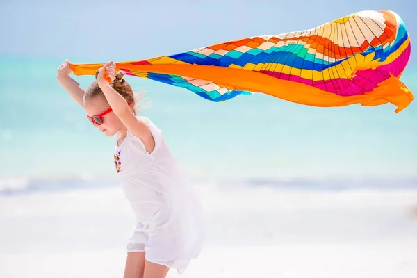 La niña se divierte en la playa. Kid disfrutar de vacaciones en la playa con pareo —  Fotos de Stock