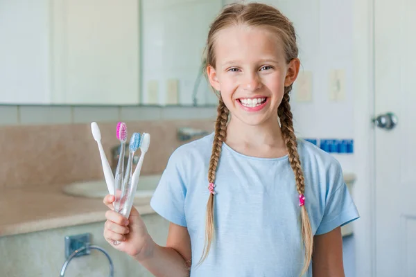 Kleines schönes Mädchen mit weißen Zähnen putzt Zähne im Badezimmer — Stockfoto
