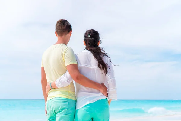 Молодая пара на белом пляже во время летних каникул. Счастливая семья наслаждается отпуском — стоковое фото