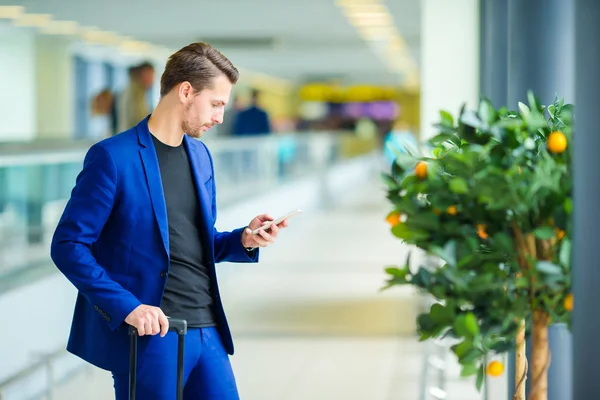 Jonge man in luchthaven met bagage wachten instappen — Stockfoto