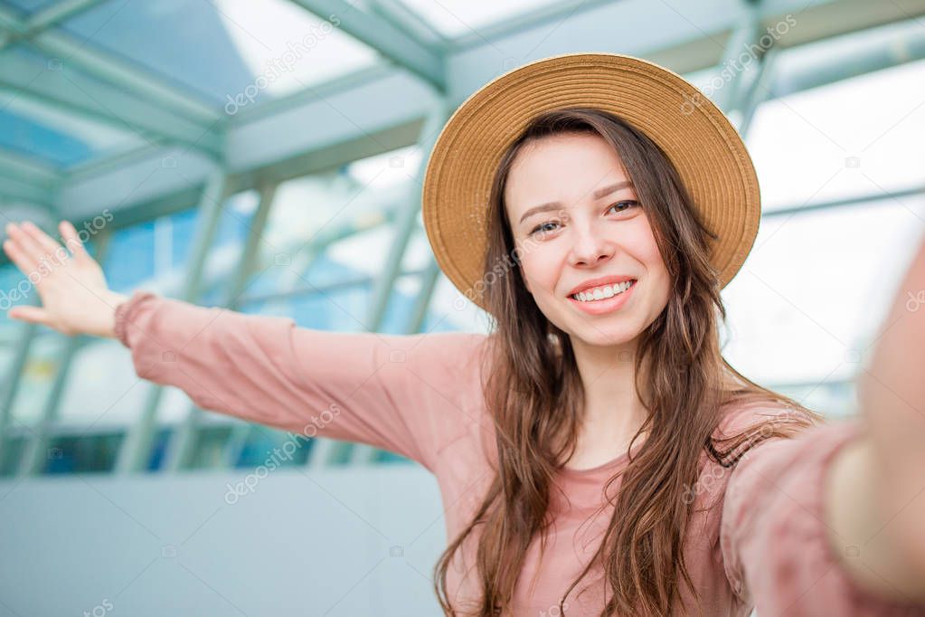 Young woman taking selfie an airport lounge waiting for boarding in international airport