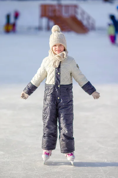 Adorabile bambina che pattina in inverno giornata sulla neve all'aperto — Foto Stock