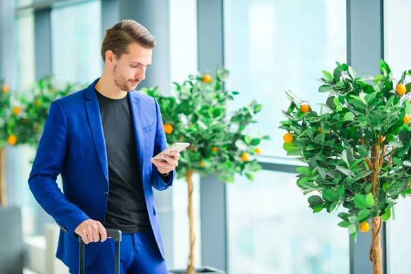 Jonge man in luchthaven met bagage wachten instappen — Stockfoto