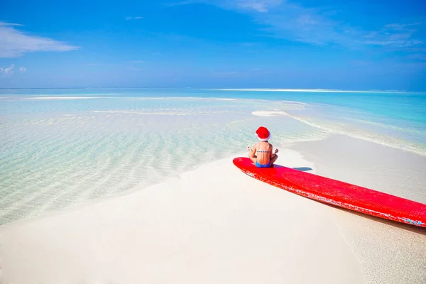 Chrismas tatil sırasında beyaz plaj Santa şapka, küçük kız — Stok fotoğraf