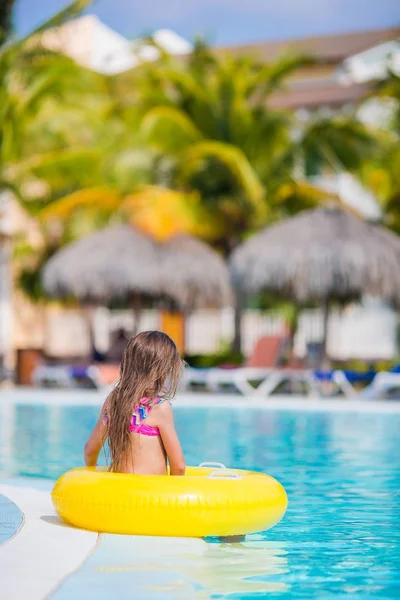 Menina pequena com círculo de borracha inflável na piscina exterior — Fotografia de Stock