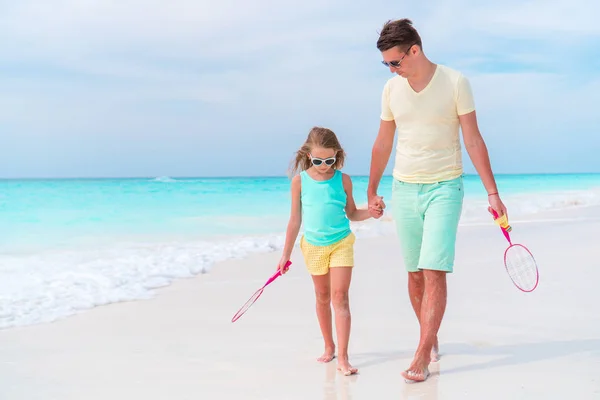 Little girl playing tennis with father on white tropical beach — Stock Photo, Image