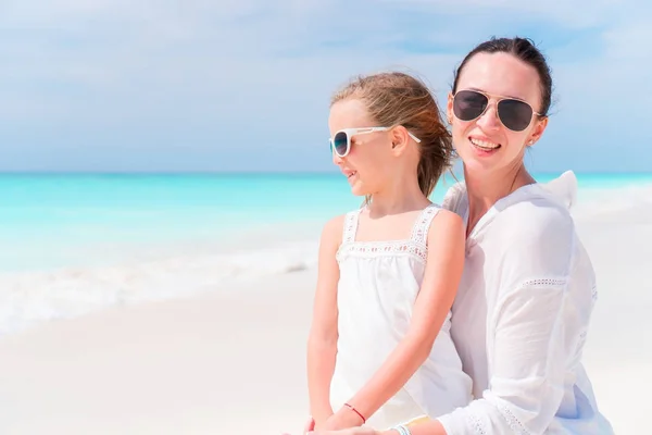 Malá rozkošná dívka a mladá matka na tropické pláži — Stock fotografie