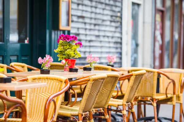 Café ao ar livre em uma rua de aldeia tradicional grega típica na Grécia. Café na mesa para o café da manhã — Fotografia de Stock