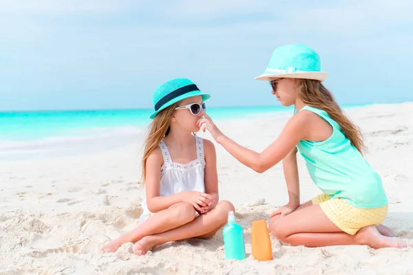 Παιδιά εφαρμόζοντας αντηλιακή κρέμα με το άλλο στην παραλία. Η έννοια της προστασίας από την υπεριώδη ακτινοβολία — Φωτογραφία Αρχείου
