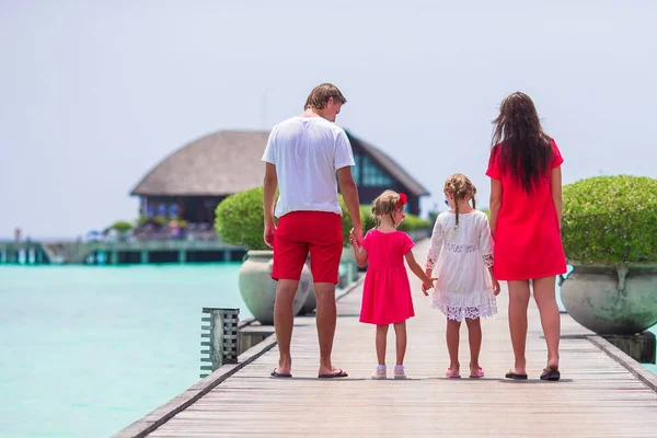 Jeune famille en rouge sur une jetée en bois aux Maldives — Photo