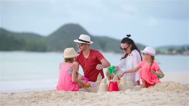 熱帯の白いビーチで砂の城を作る家族 — ストック動画