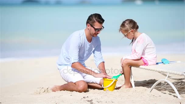 Père et petite fille faisant château de sable à la plage tropicale — Video