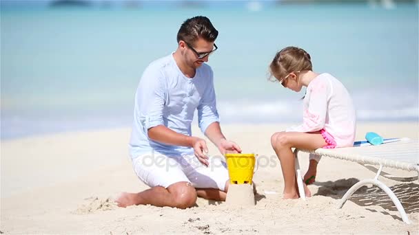 Vater und kleines Kind basteln Sandburg am tropischen Strand — Stockvideo