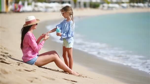 Giovane madre che applica la crema solare alla mano del bambino all'aperto — Video Stock