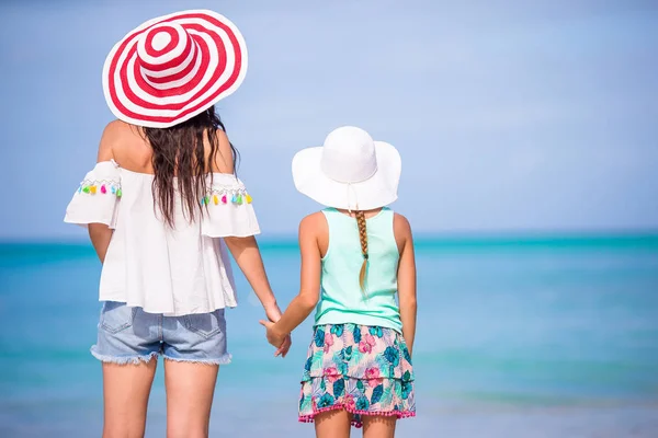 Pequena menina adorável e jovem mãe na praia tropical — Fotografia de Stock