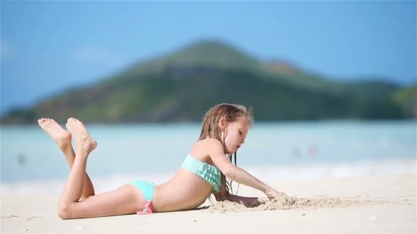 Schattig klein meisje op het strand met veel plezier in ondiep water — Stockvideo