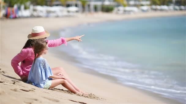 Kis lány és fiatal anya a fehér strand — Stock videók