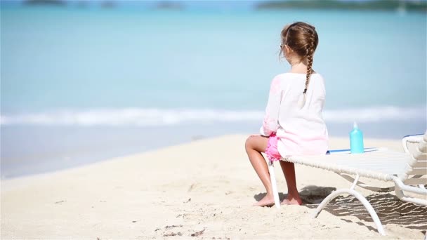 Meisje genieten op zonnebank op witte strand — Stockvideo