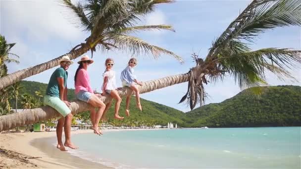 Молода сім'я на пляжі відпочинку на пальмових дерев. Батьки і діти весело разом на узбережжі Карибського моря на Антигуа — стокове відео