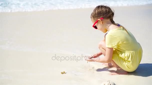 Adorable little girl playing with sand on white beach. Happy kid enjoy vacation on caribbean island — Stock Video