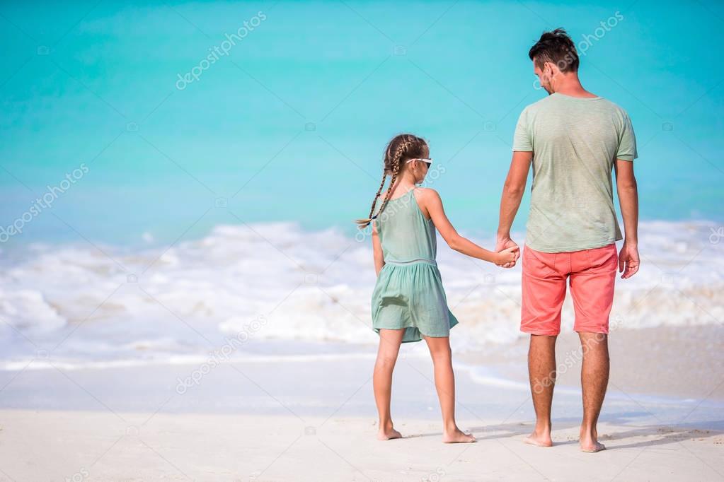 Family at tropical beach walking together in caribbean island of Antigua and Barbuda