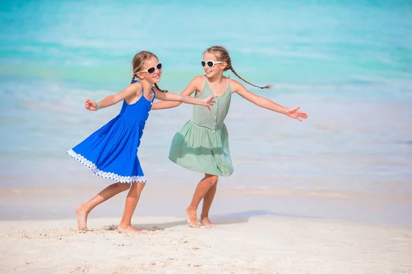 Schattige kleine meisjes hebben veel plezier op het strand. Twee mooie kinderen zijn gelukkig. — Stockfoto