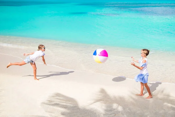 Маленькие очаровательные девочки играют с мячом на пляже — стоковое фото