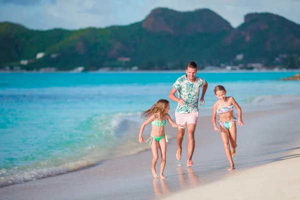 Счастливый отец с детьми играет на пляже. Счастливая семья веселится во время летнего пляжного отдыха — стоковое фото