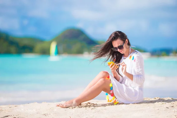 在热带海滩的年轻妇女与电话。美丽的女孩在海滩与手机在加勒比海岛 — 图库照片