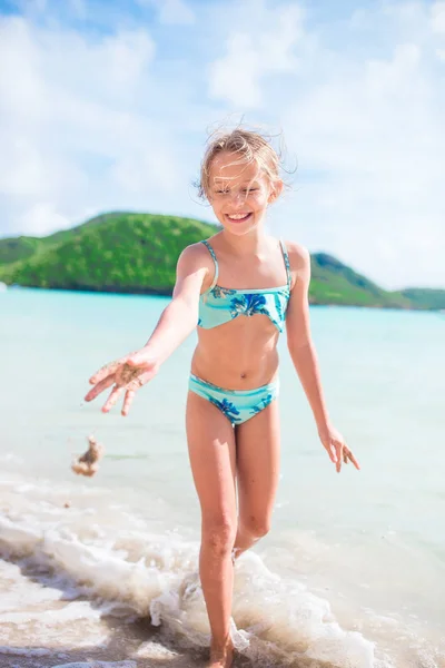 Fetiţă fericită stropind şi distrându-se în apă superficială. Copil în costum de baie jucându-se cu nisip — Fotografie, imagine de stoc
