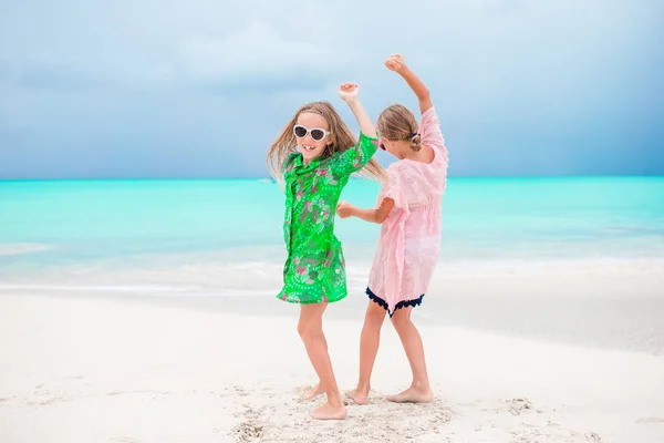 Roztomilé holčičky mají spoustu zábavy na pláži. Dvě krásné děti jsou šťastné — Stock fotografie