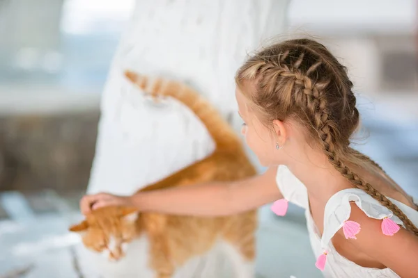 Yunan village, Mykonos, Yunanistan oynayan bir kedi Closeup küçük sevimli kız — Stok fotoğraf