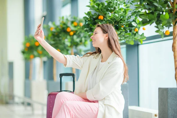 Красивая женщина в международном аэропорту. Турист с закрытым смартфоном — стоковое фото