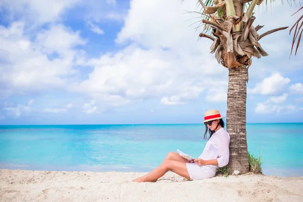 Giovane donna che legge libro durante la spiaggia tropicale bianca — Foto Stock