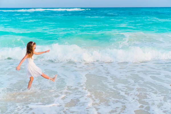 Adorável menina na praia se divertindo muito em águas rasas — Fotografia de Stock