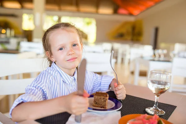 Adorable niña tomando el desayuno en la cafetería al aire libre —  Fotos de Stock