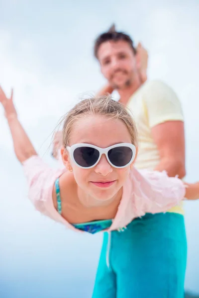 夏休みの間に屋外の小さな女の子は、父親と楽しい時を過します。空の背景に逆さまの子供の肖像画 — ストック写真